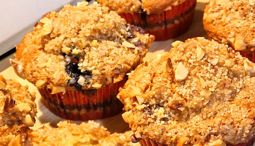 Muffin ai mirtilli in pirottini di carta rossi su tagliere di legno