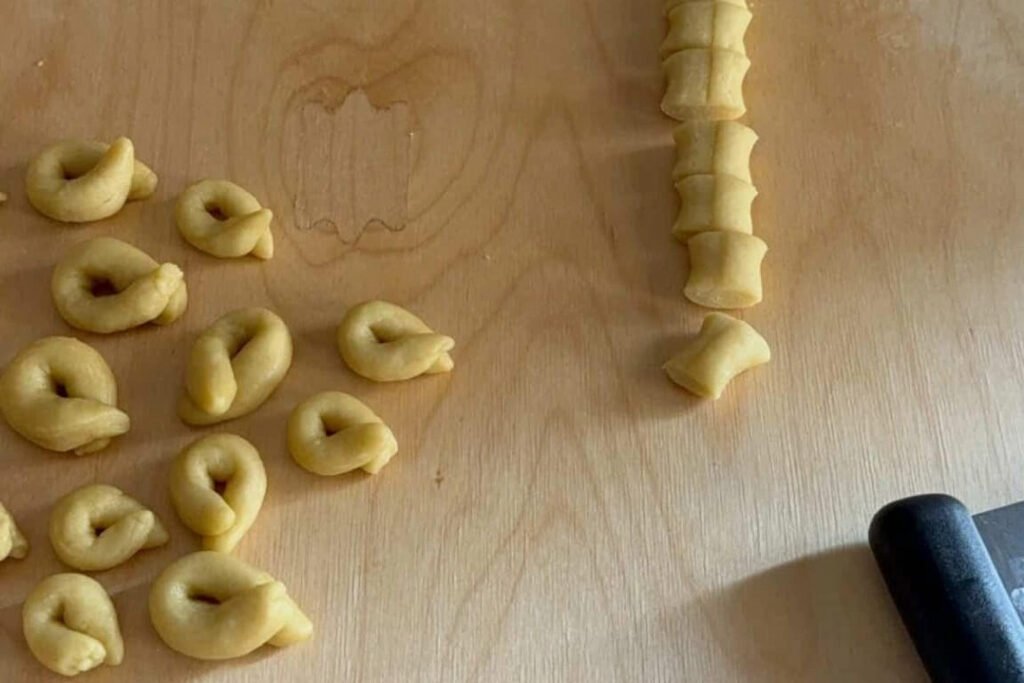 Impasto crudo per taralli pugliesi tagliato a tocchetti e alcuni taralli già formati