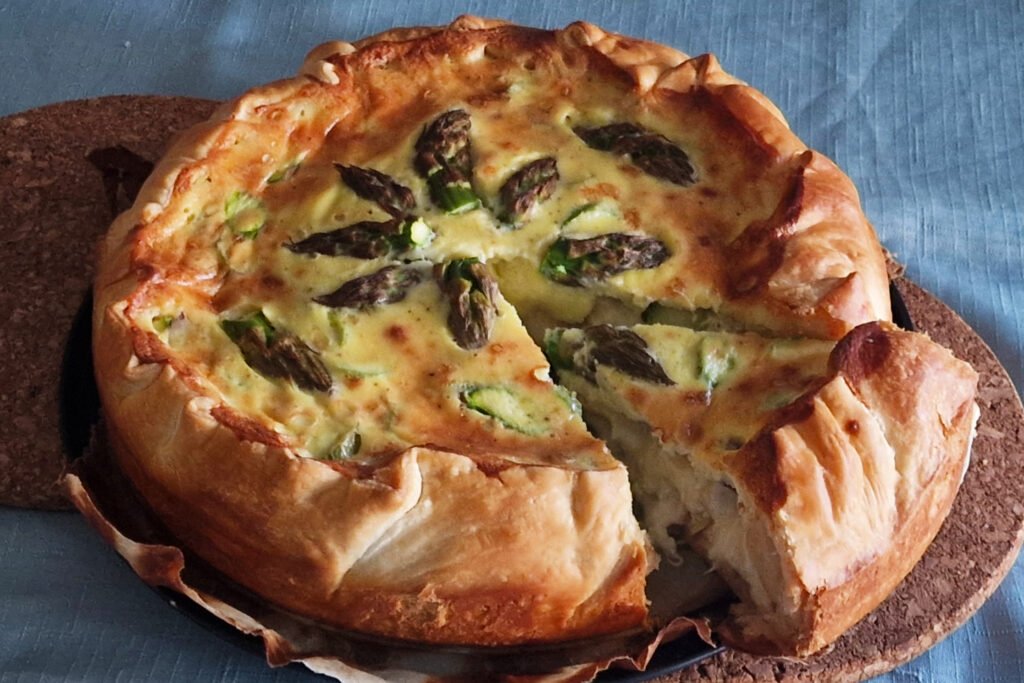 Torta salata di asparagi con uno spicchio tagliato