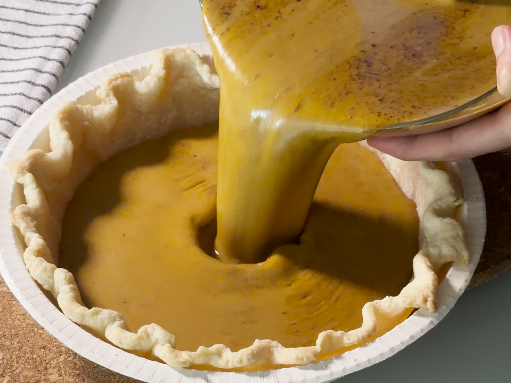 Ripieno pumpkin pie versato nel guscio di impasto